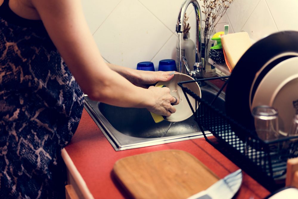 Woman is cleaning dishes at home.