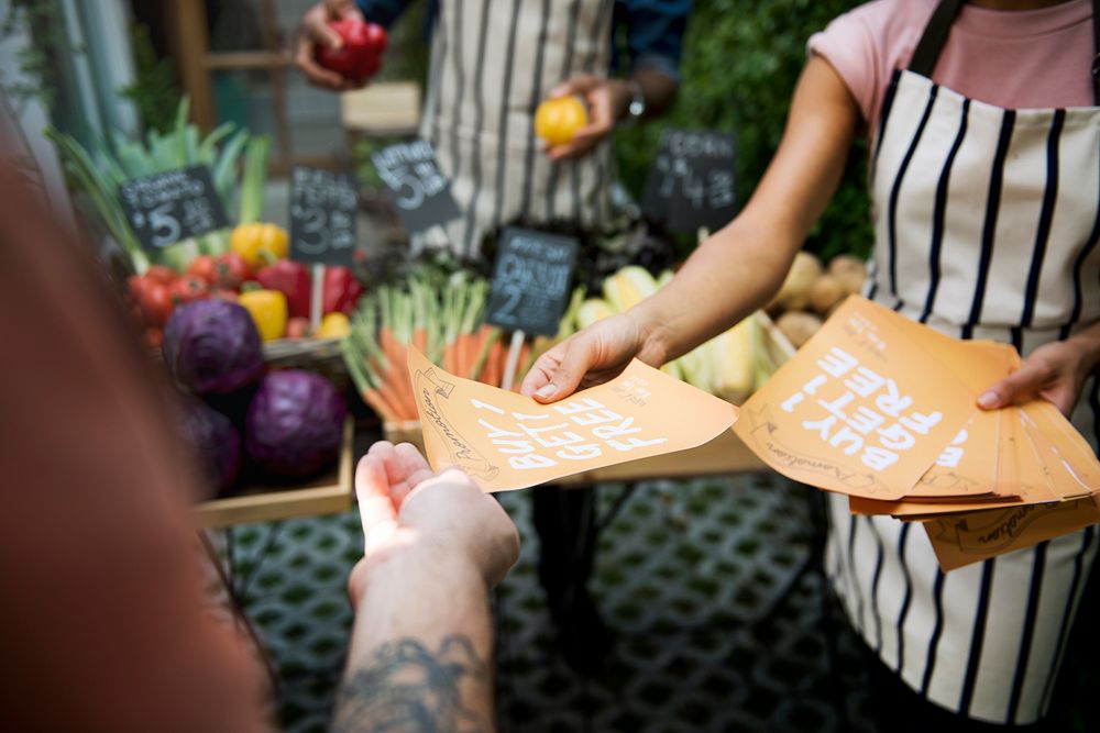 People Handing Out Promotion Brochure to Customer