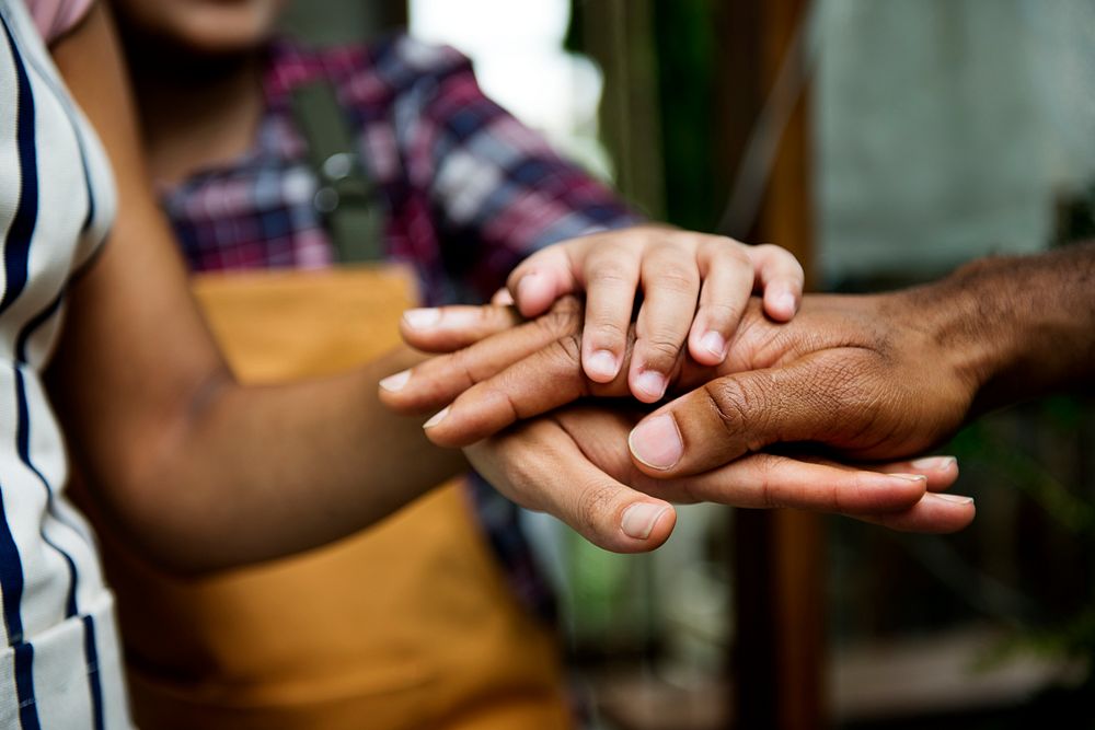 Closeup of diverse hands joined together as teamwork