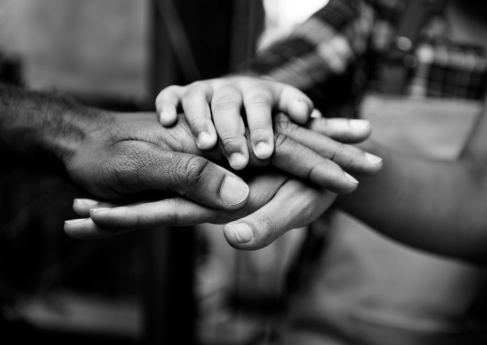 Closeup of diverse hands joined together as teamwork