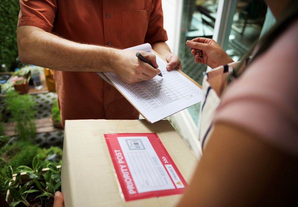 Closeup of hand signing on delivery paper