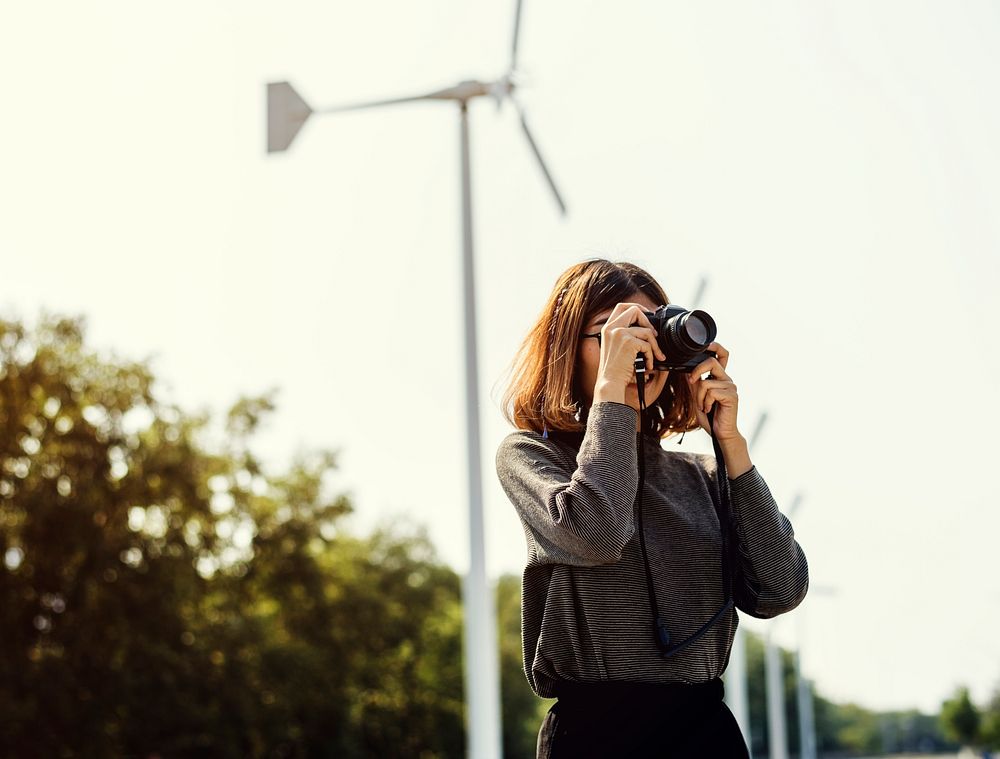 Woman at windmill field taking a photo