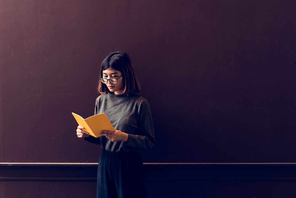 Girl with Glasses Standing Reading Book