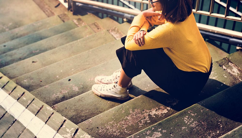 Girl with Glasses Yellow Sweater Sitting on the Stairs