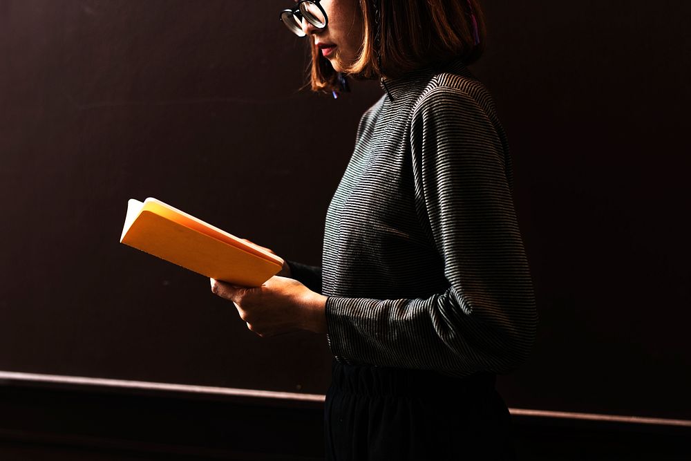 Girl with glasses reading a book