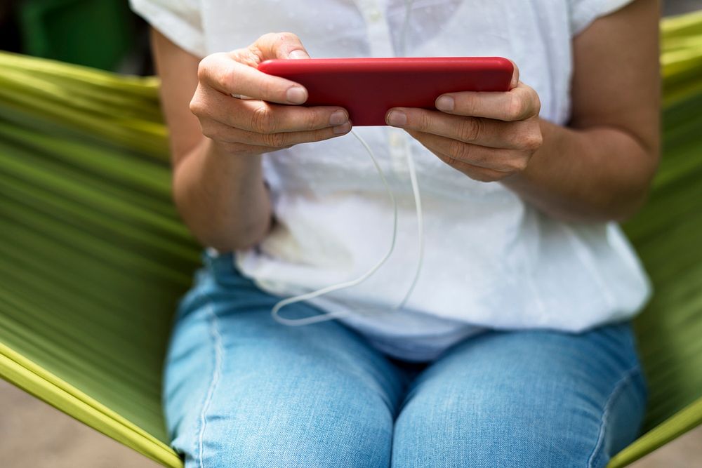 An Adult Woman Using Mobile Phone on a Hammock