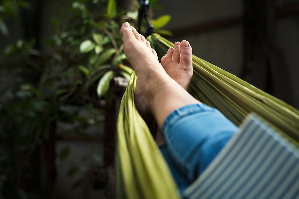 Woman lying on hammock chilling reading book