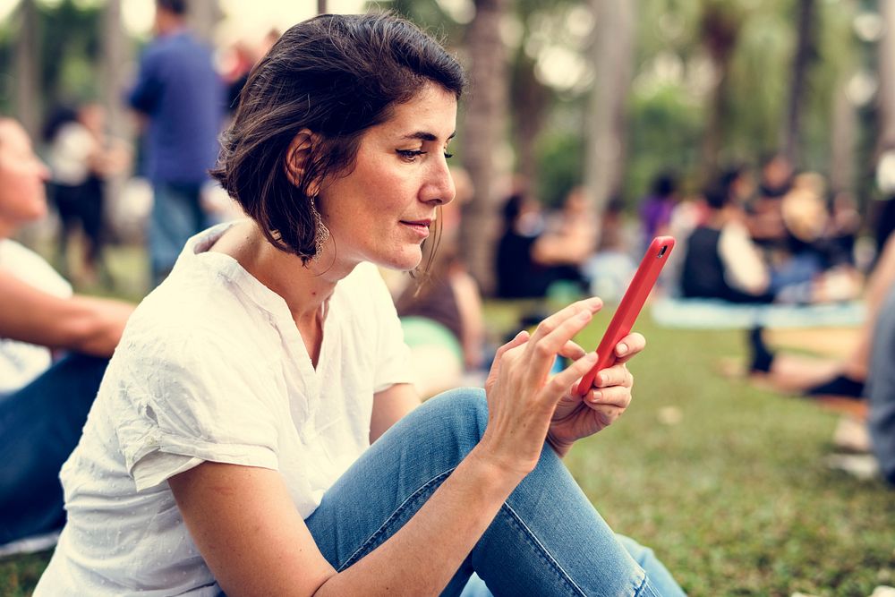 Adult Woman Sitting in The Park Using Mobile Phone