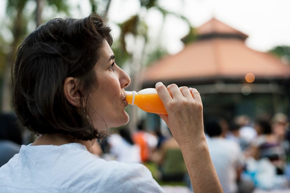 Woman leisure in a park drinking juice