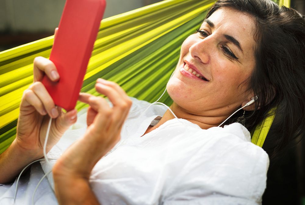 An Adult Woman Using Mobile Phone on a Hammock