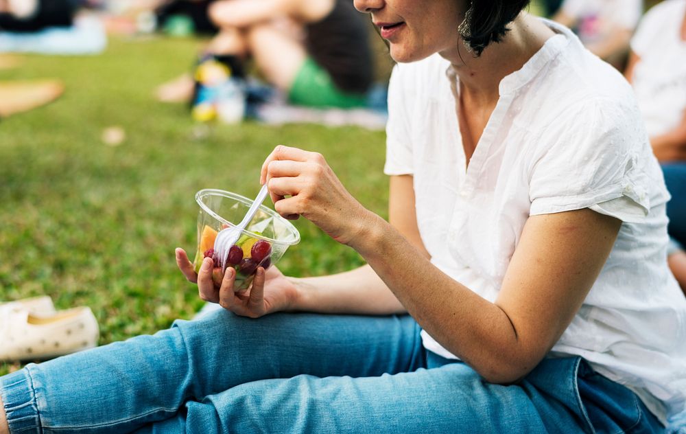 Woman eating fruit picnic at park