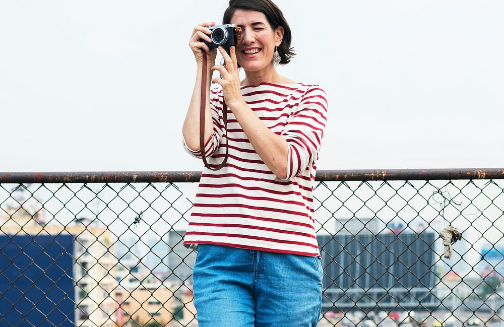 An Adult Woman With Camera Capturing Snapshots Outdoor