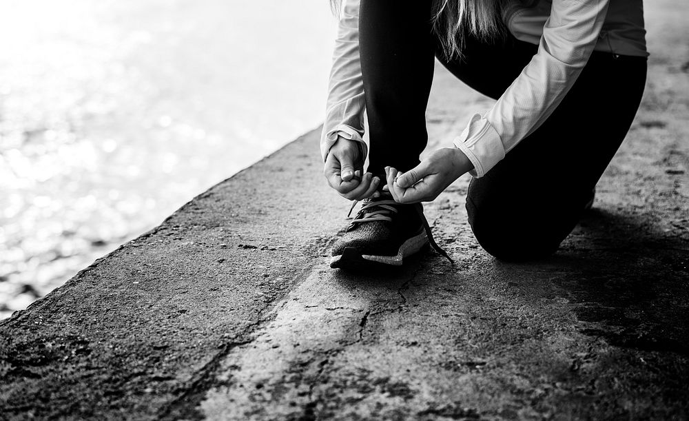 Jogger on a break tying her shoelaces