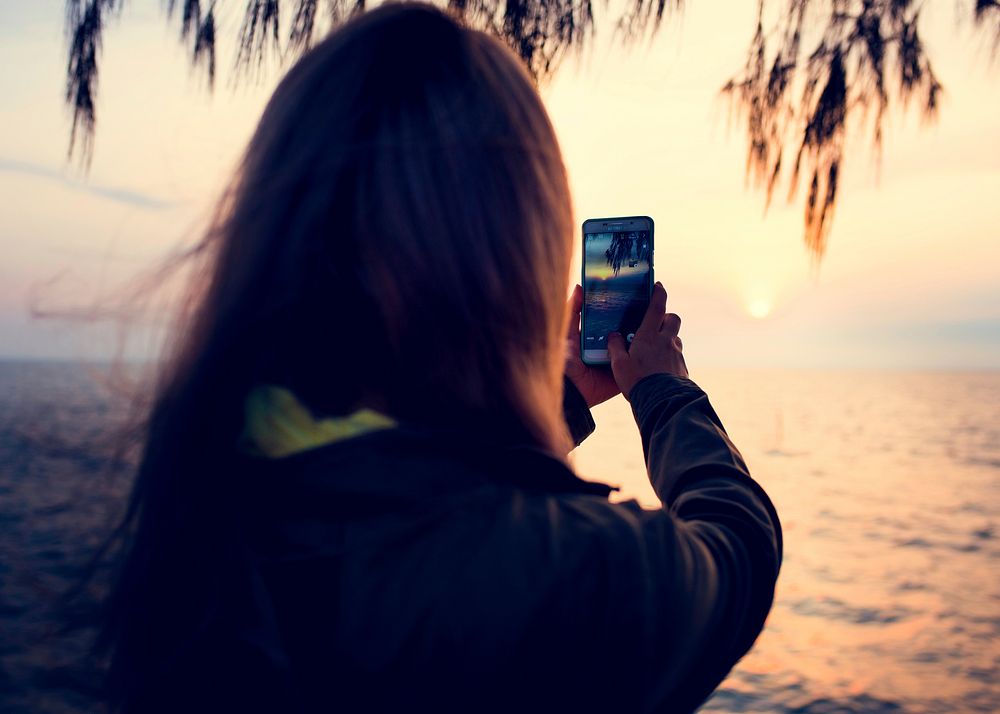 Woman taking photo on the beach