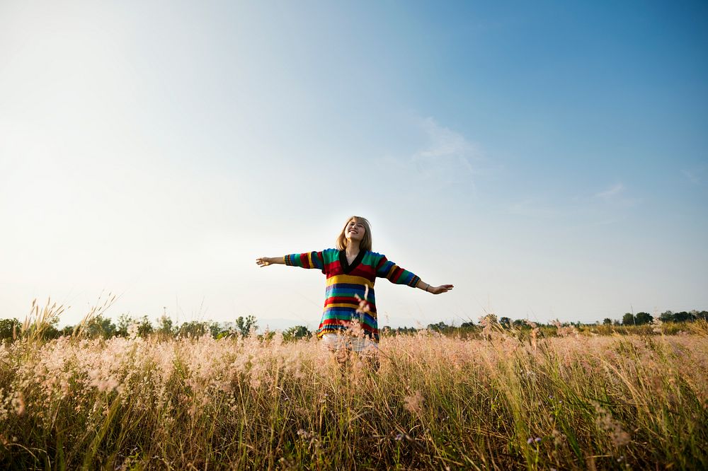 Woman with arms outstretched in the middle of the meadow