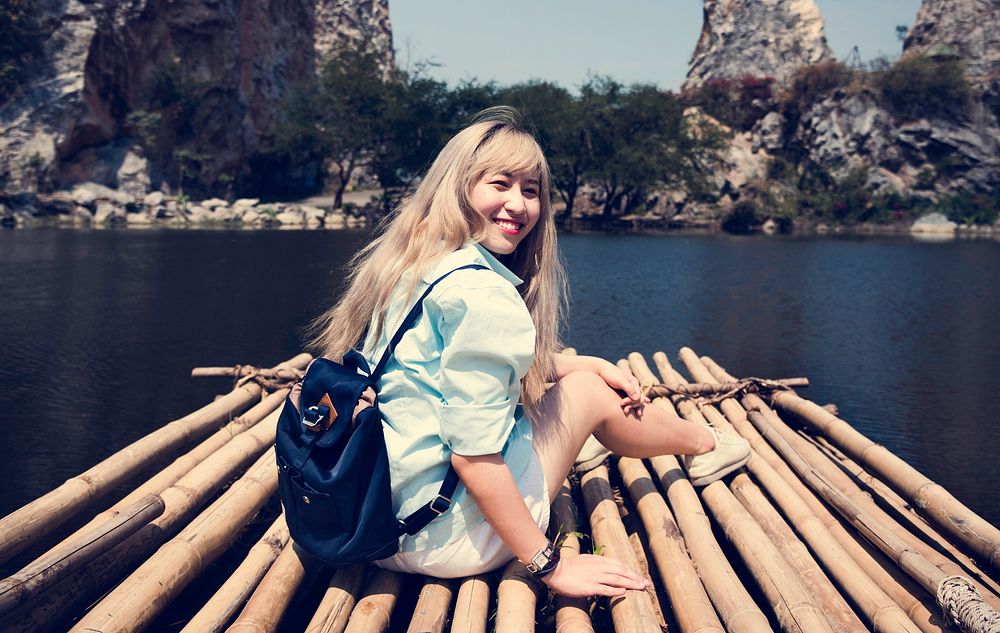 Backpack Traveler Woman is on a raft in a lake
