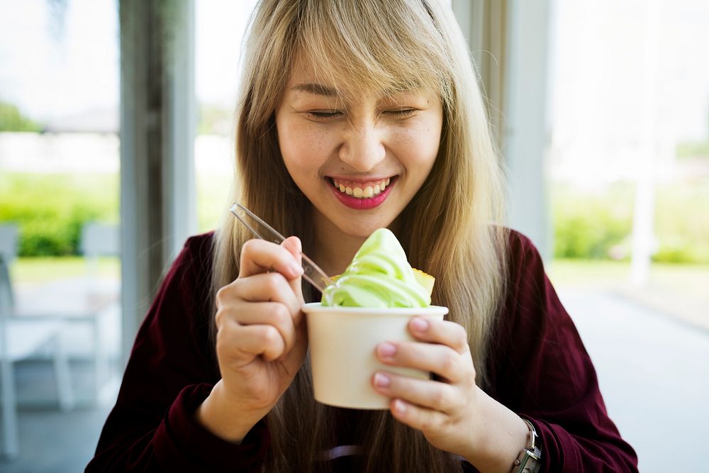 Woman eating a cup of green ice-cream