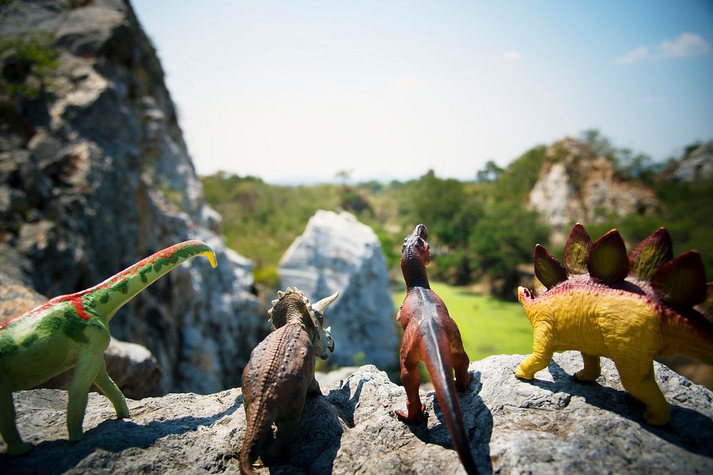 Group of dinosaur toys on a rock