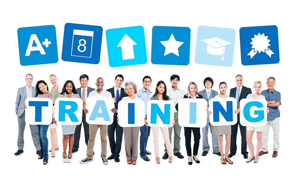 Multi-ethnic group of business and casual people holding cardboards forming training and related symbols above.