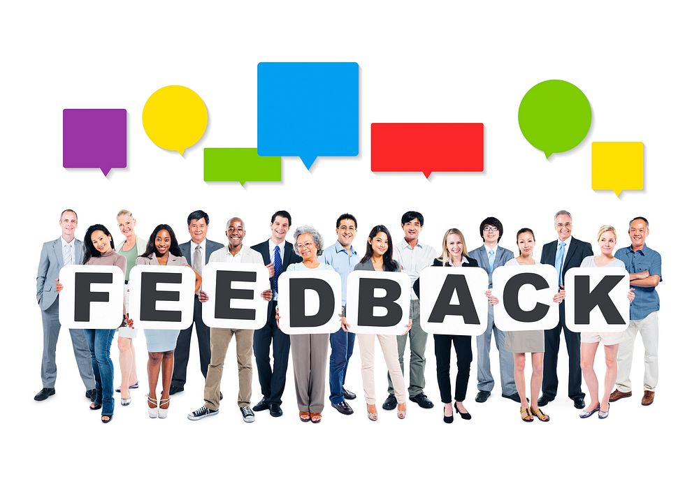 Multi-Ethnic Group Of Diverse People Holding Letters That Form Feedback And Colorful Empty Speech Bubbles Above
