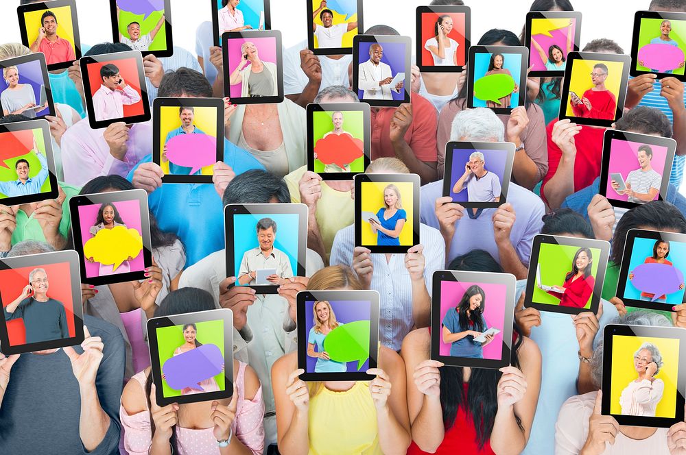 Multi-ethnic group of people holding tablets in front of the faces