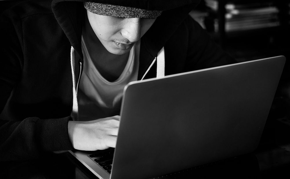 Young guy in a hoodie using laptop