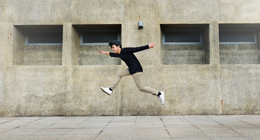 Asian guy midair jumpshot outdoors