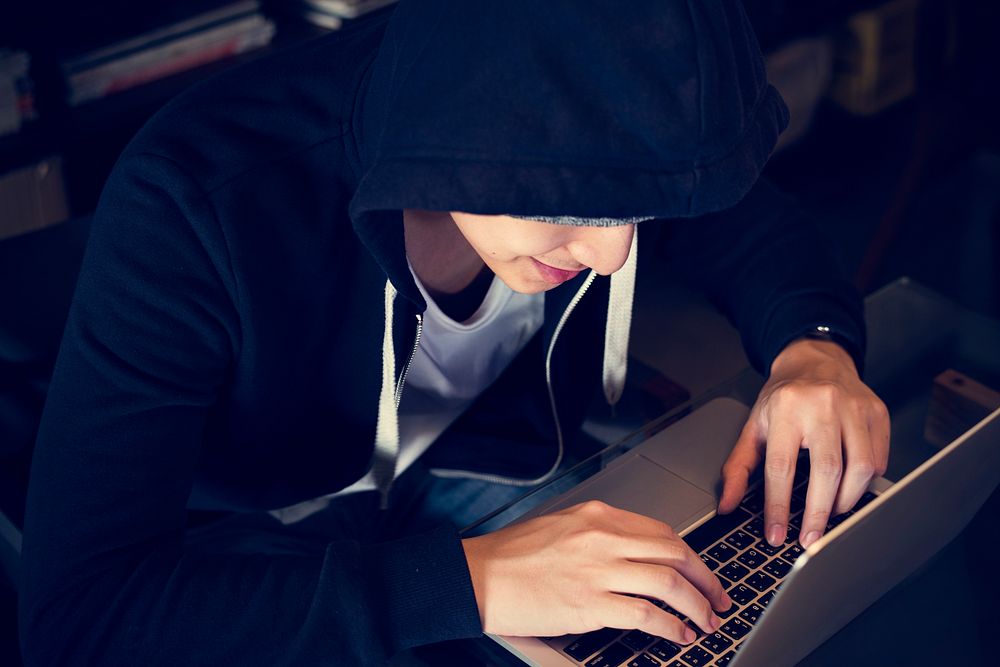 Young asian boy wearing hoodie using digital laptop