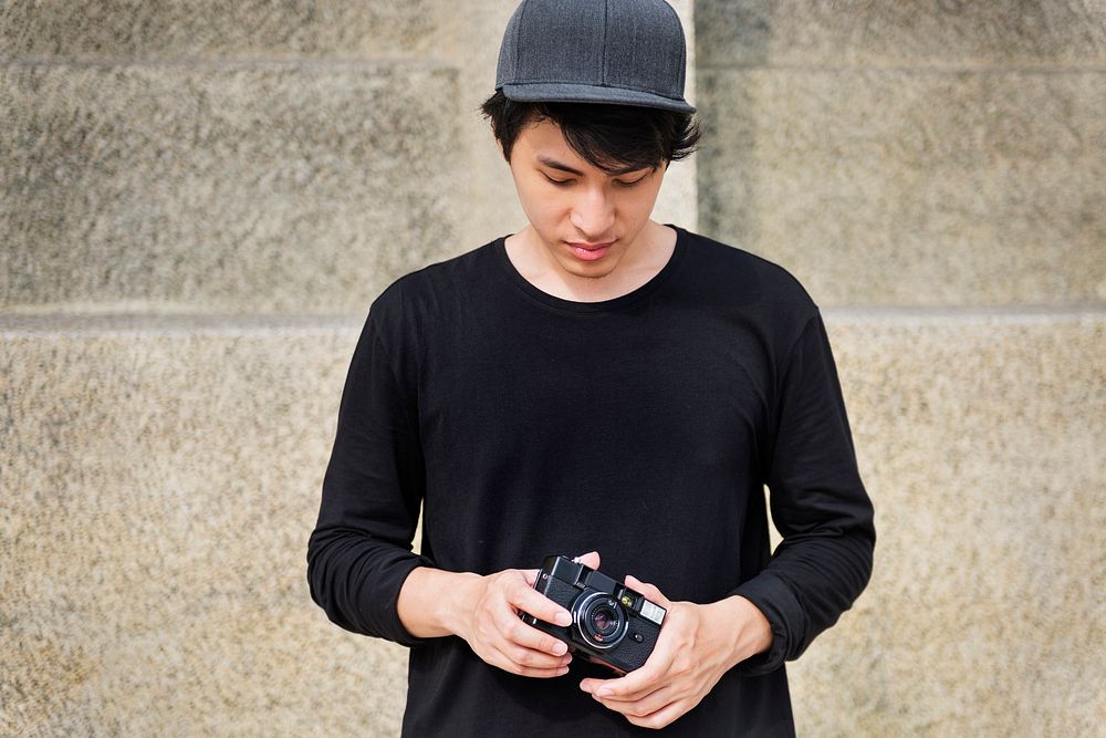 Young adult asian guy holding camera