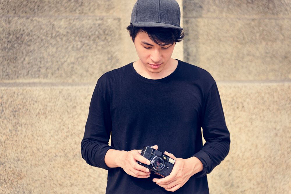 Young adult asian guy holding camera