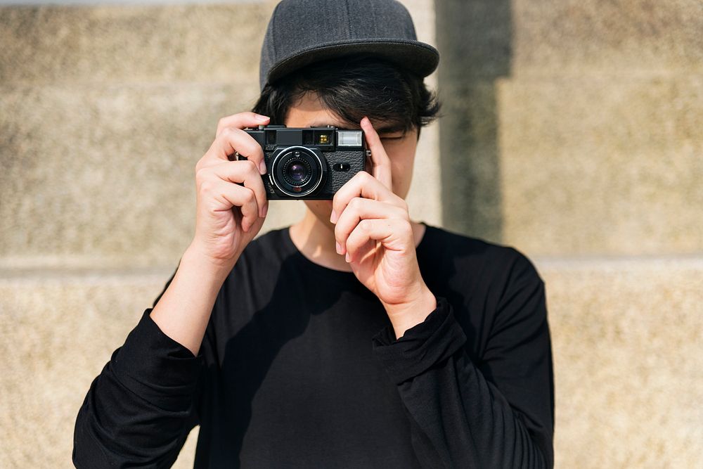 Asian guy takes photo with camera