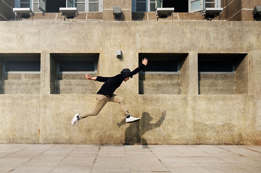 Asian guy midair jumpshot outdoors