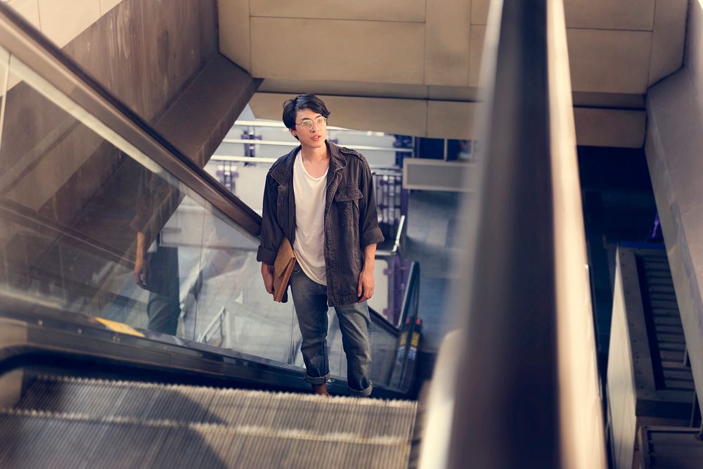 Asian man on escalator going up