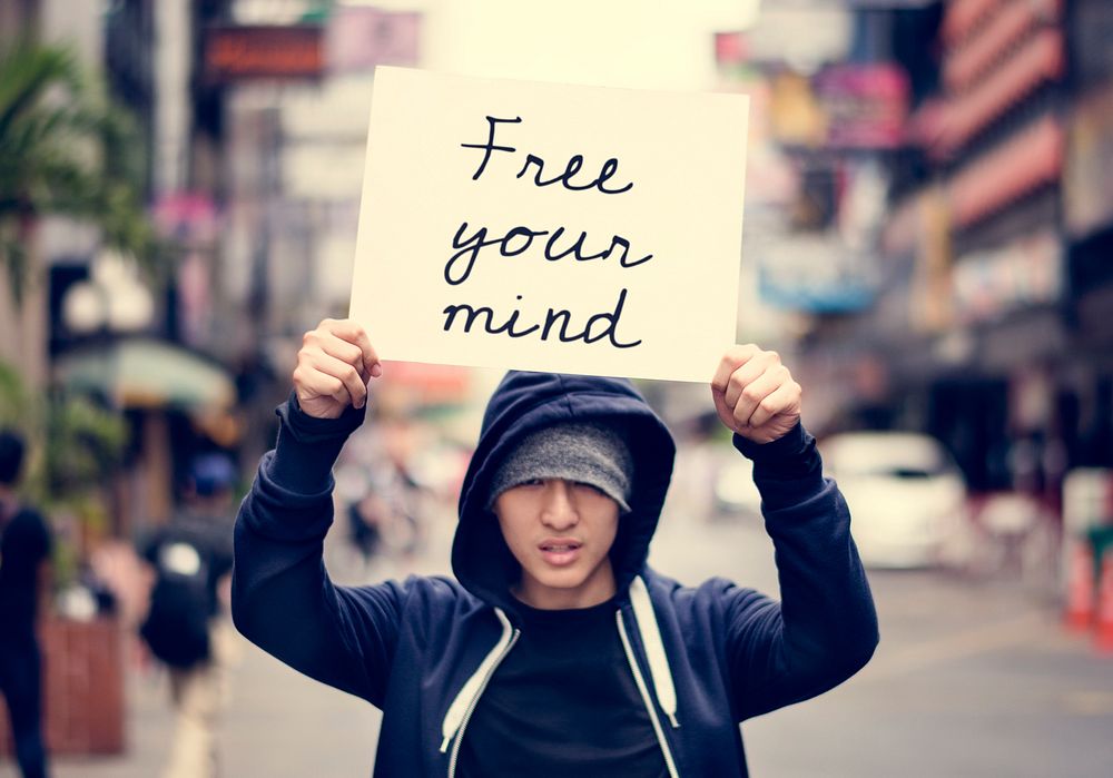 Asian guy holding placard free your mind motivation