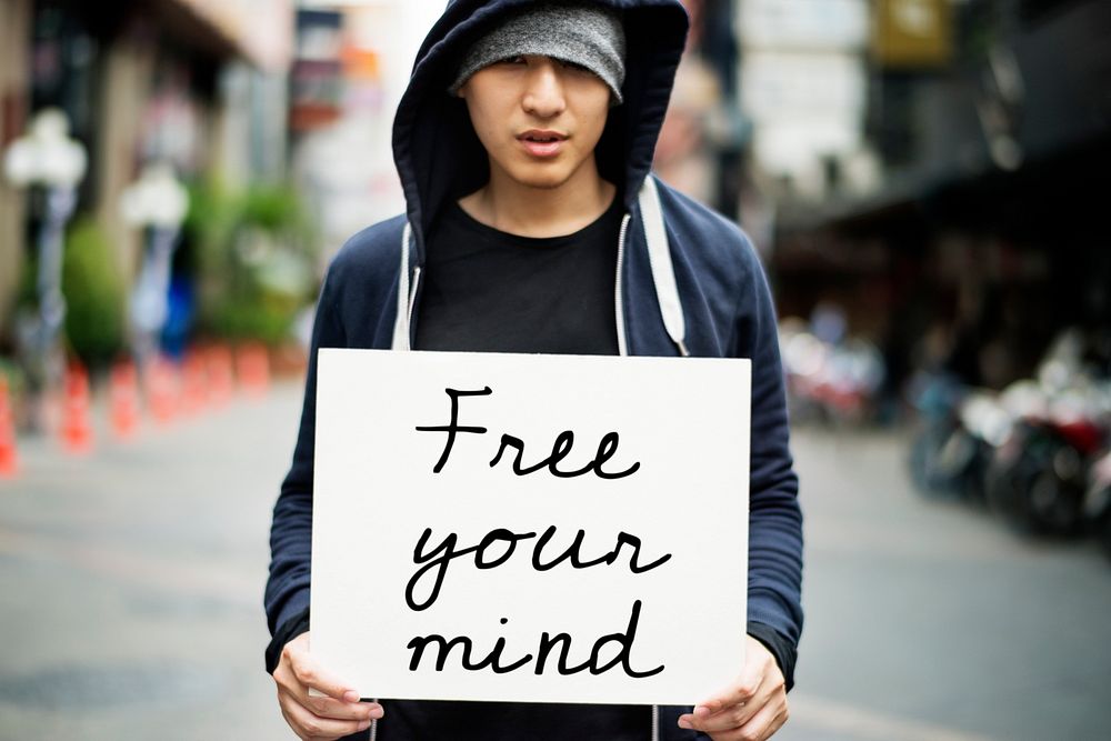 Young asian guy with a Free Your Mind placard