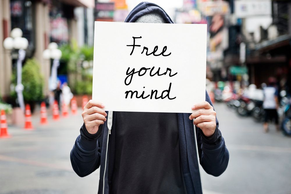 Asian guy holding placard free your mind motivation
