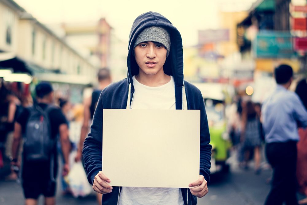 Young man holding empty placard outdoor