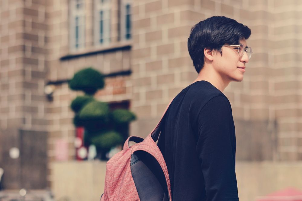 Young asian student man walking in university