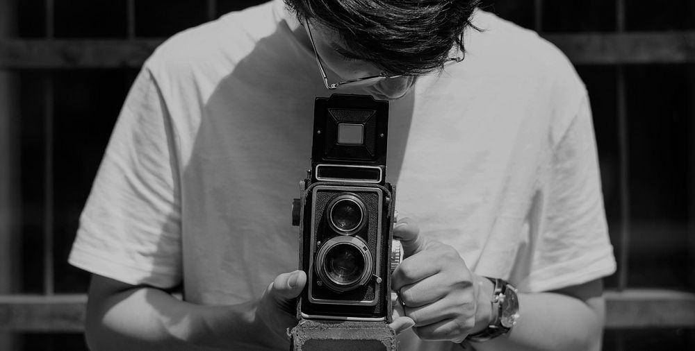 Young guy taking photos with a vintage camera