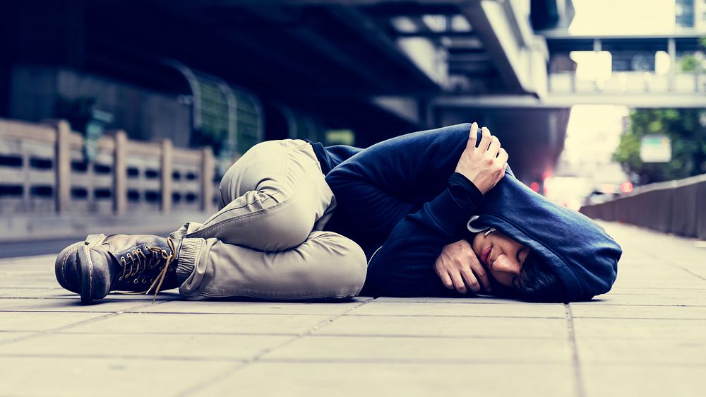 Lonely man falling down on the ground in urban scene