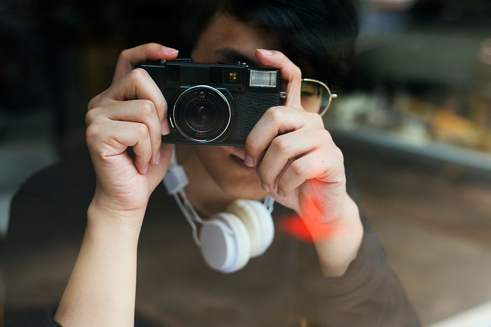 Young guy taking photos from a cafe