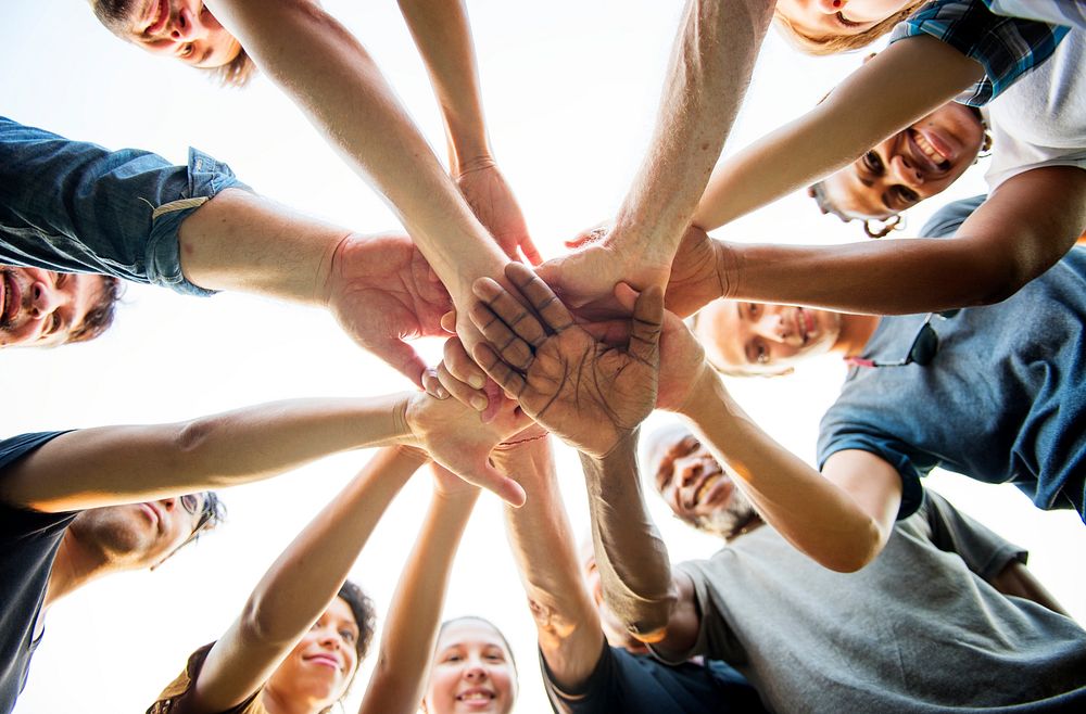 Group of people holding hand assemble togetherness from underneath