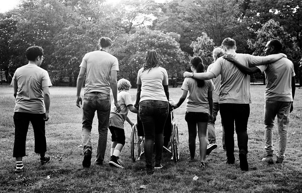 Group of friends supprt and walking together in rear view