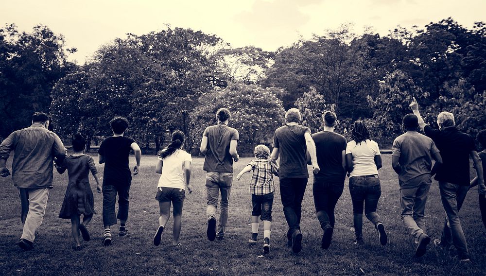 Group of people walking and running playful in the park