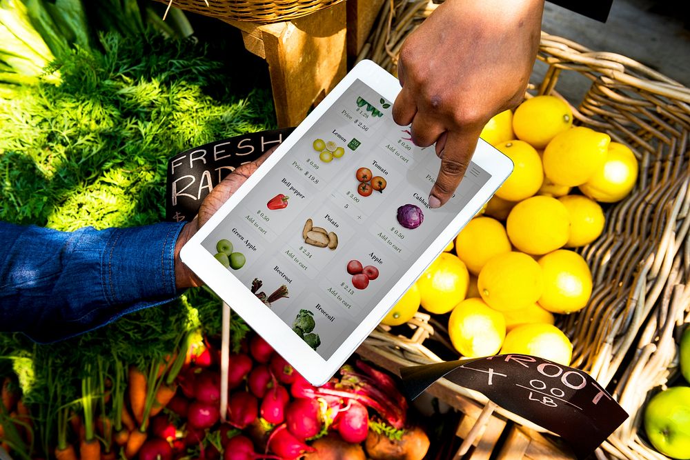 Hand using digital tablet in aerial view on vegetable and fruit