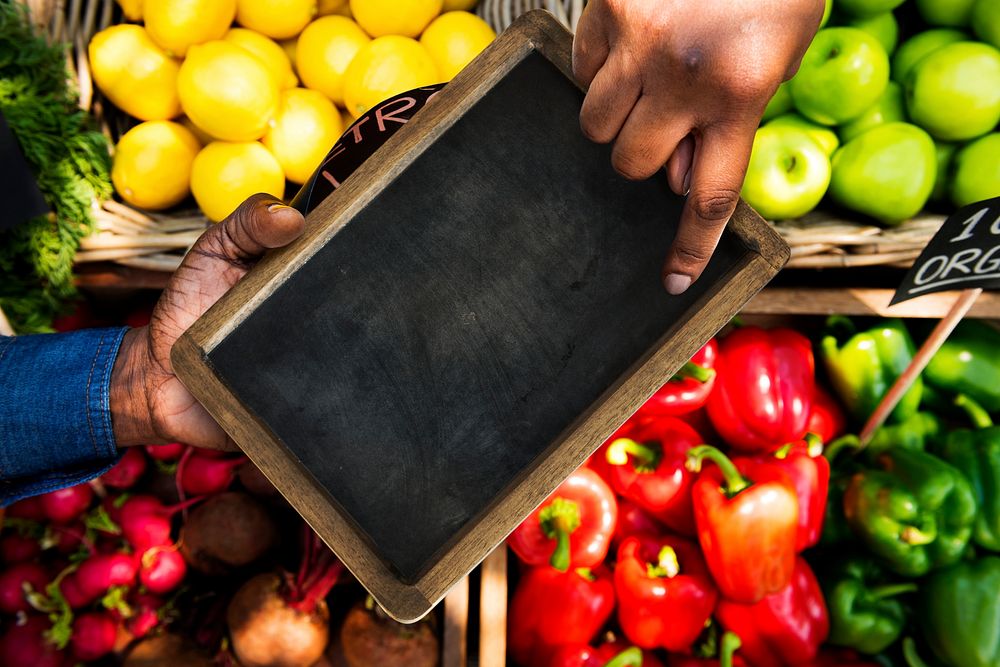 Hand pointing at blackboard in aerial view on vegetable and fruit