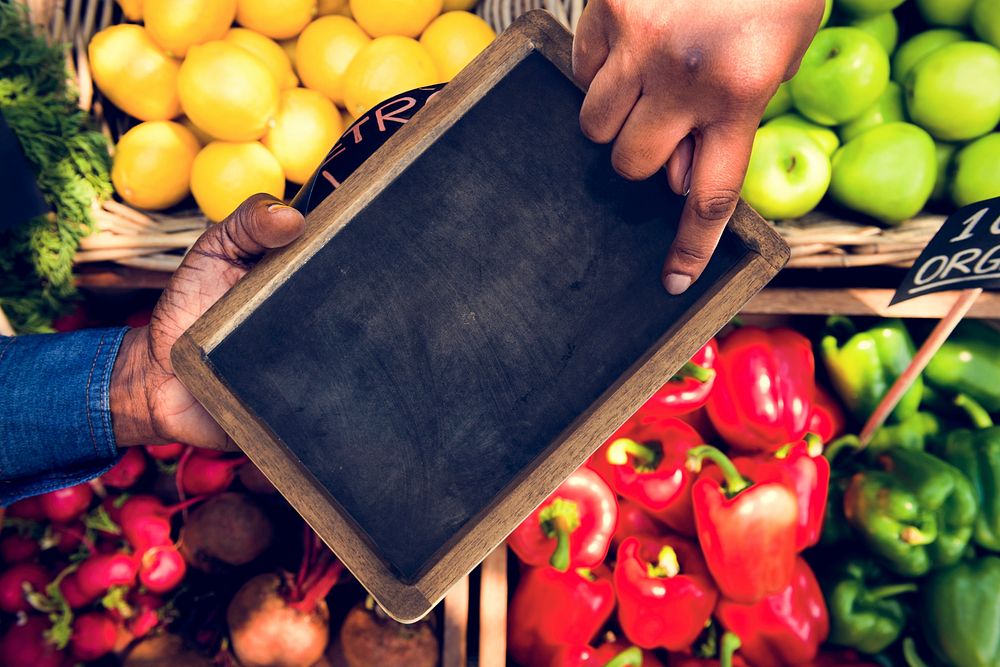 Hand pointing at blackboard in aerial view on vegetable and frui