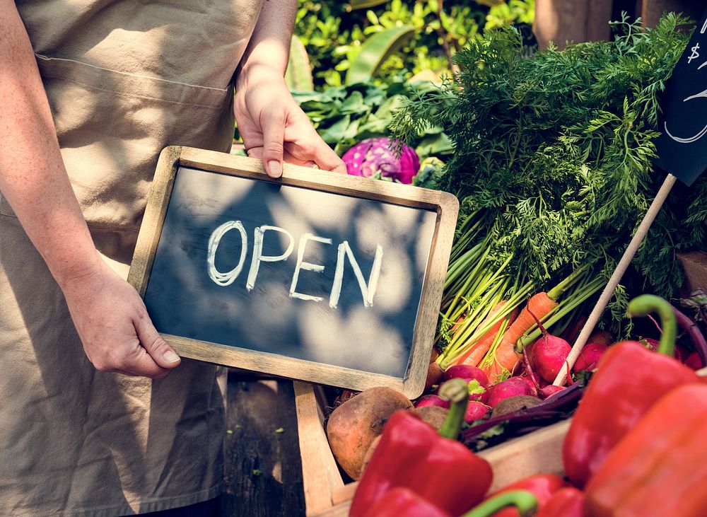 Greengrocer selling organic fresh agricultural product at farmer