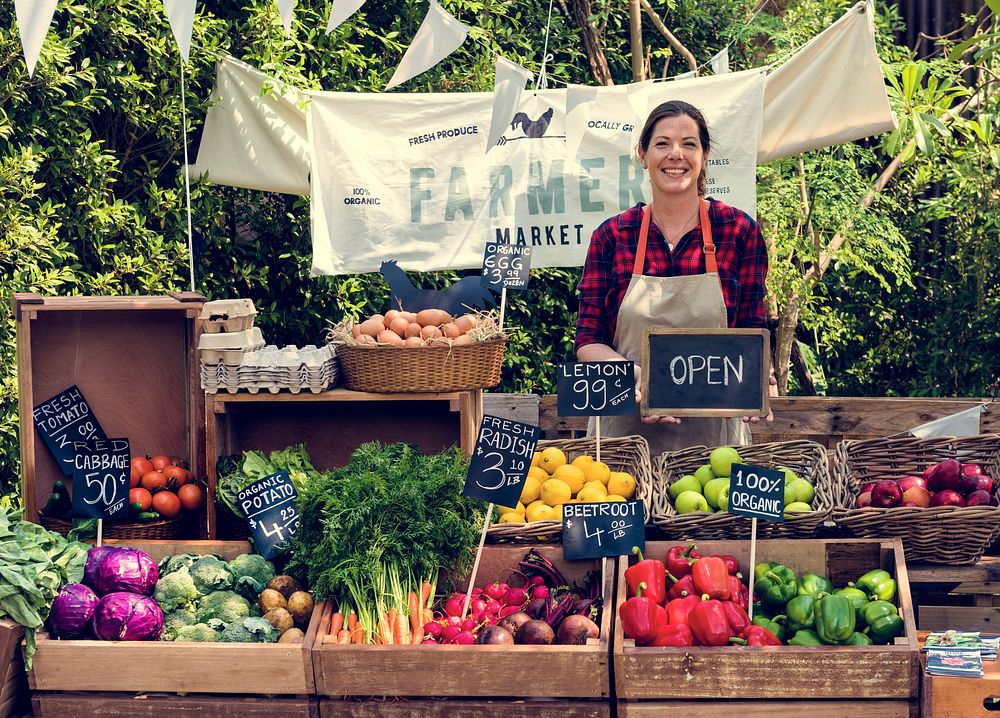 Greengrocer selling organic fresh agricultural product at farmer