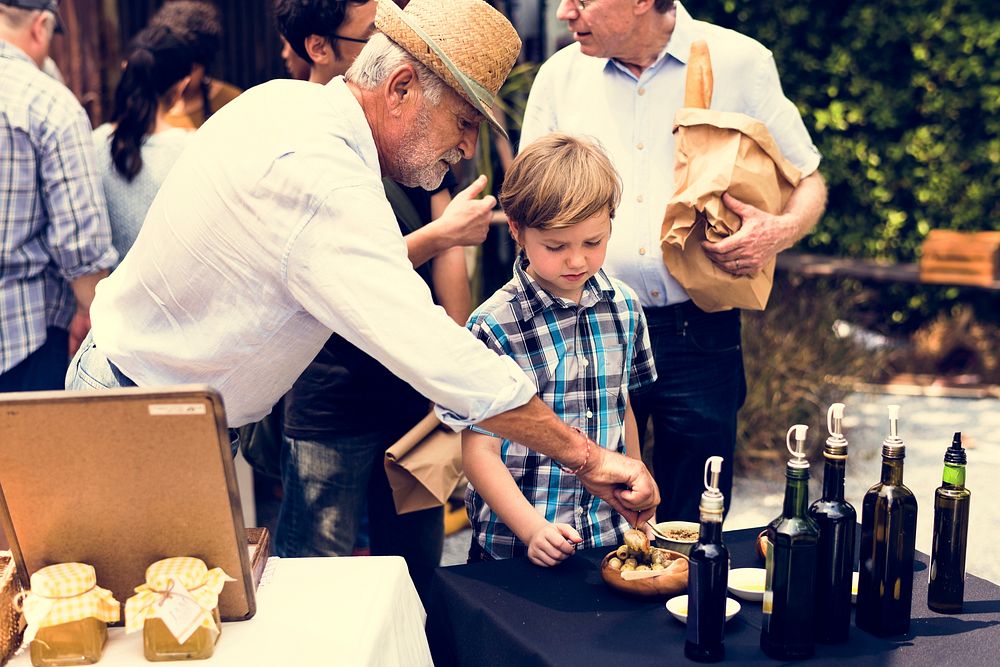 Little Boy Testing Preserve Olive Sample at Market